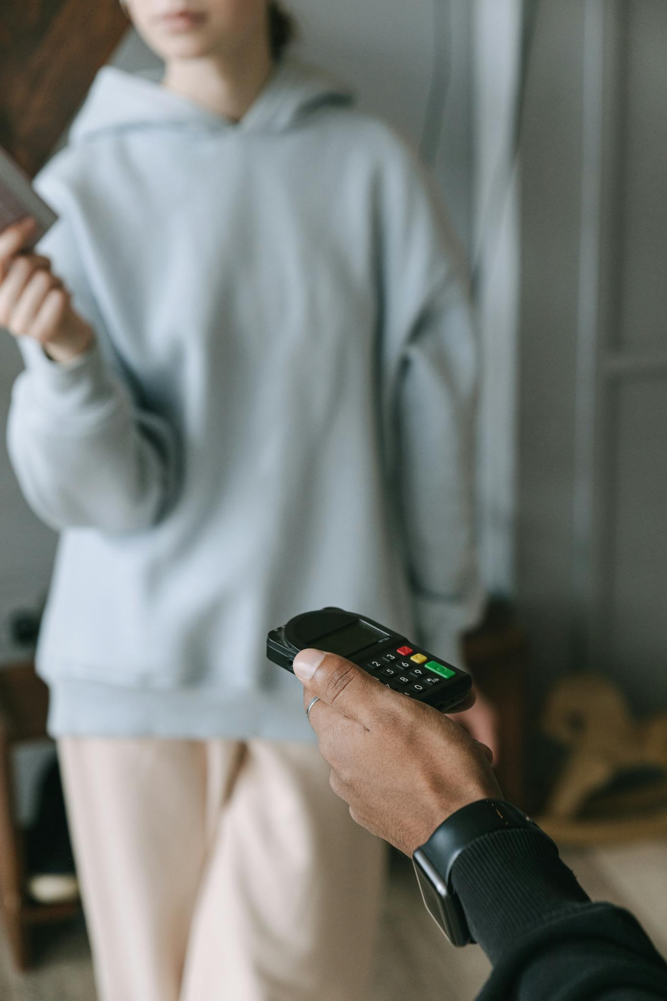 A close-up of a cashless payment using a card reader in a store setting.